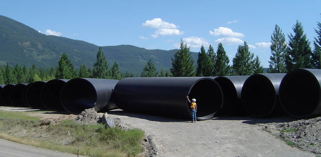 Many Weholite pipe components with a diameter about double the height of a man.