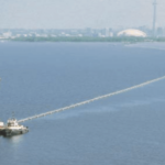 Boats laying Sclaripipe on the surface of Lake Ontario connecting to Toronto in the background.