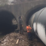 Large Weholite pipe installed underneath a road through a concrete culvert.