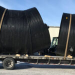 Weholite pipe strapped down on a flatbed trailer for transportation.