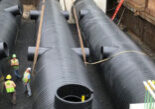 Three large Weholite pipes installed in an underground opening lined with metal walls.